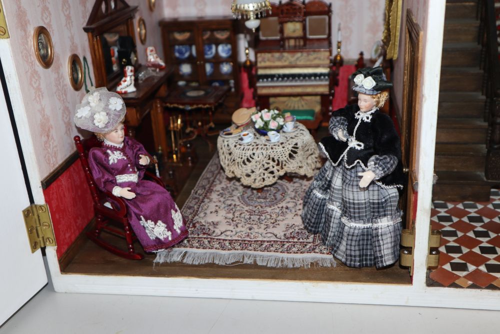 A modern Victorian style dolls house with antique and other furniture and contents including dolls, jointed miniature dolls